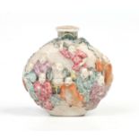 A 19th century Chinese snuff bottle. Moulded in relief with a procession of figures on a textured
