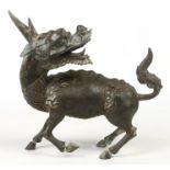 A 19th century Chinese bronze model of a Kylin stood upon three hooves and with its head turned to
