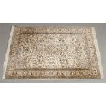A Persian Kashmir cream ground rug with a stylized floral design under a banded border, 1m 27cm x 1m