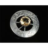 A Scottish provinacial silver roundel brooch. Set with a pale citrine and engraved with Celtic