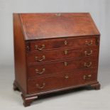 A George III mahogany bureau with fitted interior, oak drawer linings and raised on ogee bracket