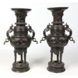 A large pair of Japanese Meiji period patinated bronze vases. With twin scrolling handles formed