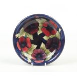 A Moorcroft dish. Ground in cobalt blue and decorated with the Pansies design. Impressed marks and