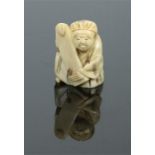 A Japanese Meiji period miniature carved ivory figure of a schollar holding a scroll and with