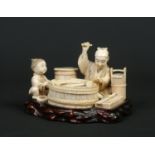 A Japanese Meiji period carved ivory okimono group on fitted hardwood plinth. Formed as a seated