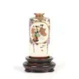 A Japanese Meiji period Satsuma cylindrical miniature vase on hardwood plinth decorated with