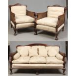 A Victorian carved mahogany and bergere three part parlour suite. With scrolling arms, double