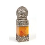 A 19th century Indian silver mounted butterscotch amber desk seal. Embossed with stylized foliage