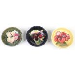 Three small Moorcroft bowls. Glazed with coloured grounds and decorated with Fuscia, Orchid and