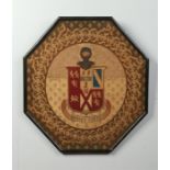 A 19th century woolwork armorial panel of octagonal form and in ebonized frame. Depicting a coat