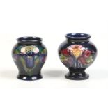 Two small Moorcroft baluster shaped vases. Ground in cobalt blue, one decorated in the Aquilegia