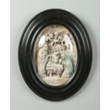 An early 20th century Continental oval composite nativity scene in ebonized frame, 29cm x 21cm.