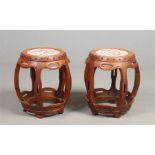 A pair of Chinese early 20th century carved hardwood barrel stools. With porcelain set seats