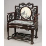 A Chinese late Qing dynasty hardwood armchair or throne with dreamstone panels. The stepped backrest