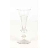 An early 19th century flat cut glass champagne flute. With a knopped stem and raised on a star cut