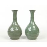 A pair of Chinese pair shaped dark celadon bottle vases. Each decorated in relief with a dragon