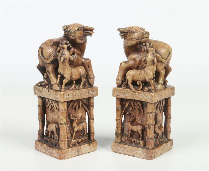 A pair of Chinese carved soapstone scholars seals. Each surmounted with a water buffalo and calf.