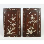 A pair of early 20th century Chinese carved hardwood panels with mother of pearl inlay depicting