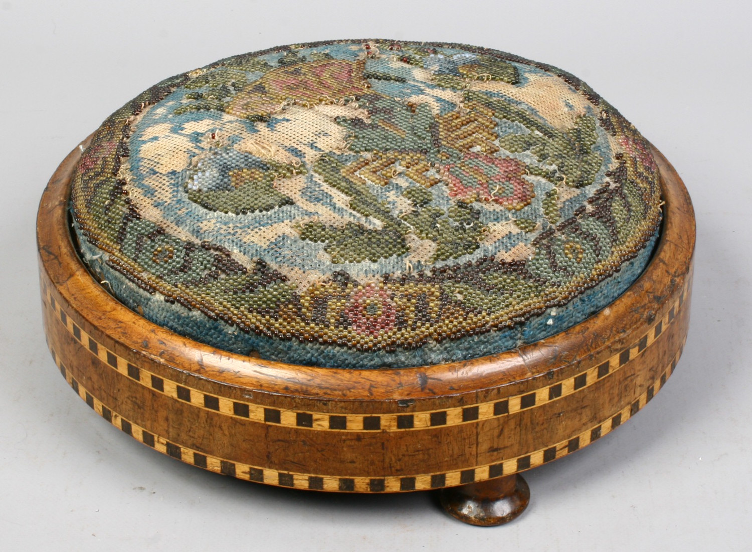 A Victorian circular footstool with beadwork top and parquetry inlay. Condition report intended as a