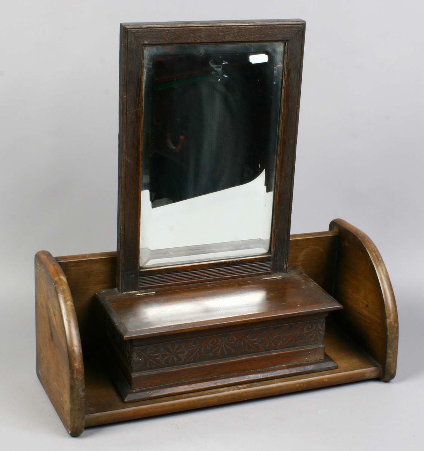 An Edwardian carved mahogany bevel edged mirror / glove box, along with a mahogany book stand.