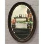A large oval mahogany framed bevel edge wall mirror.
