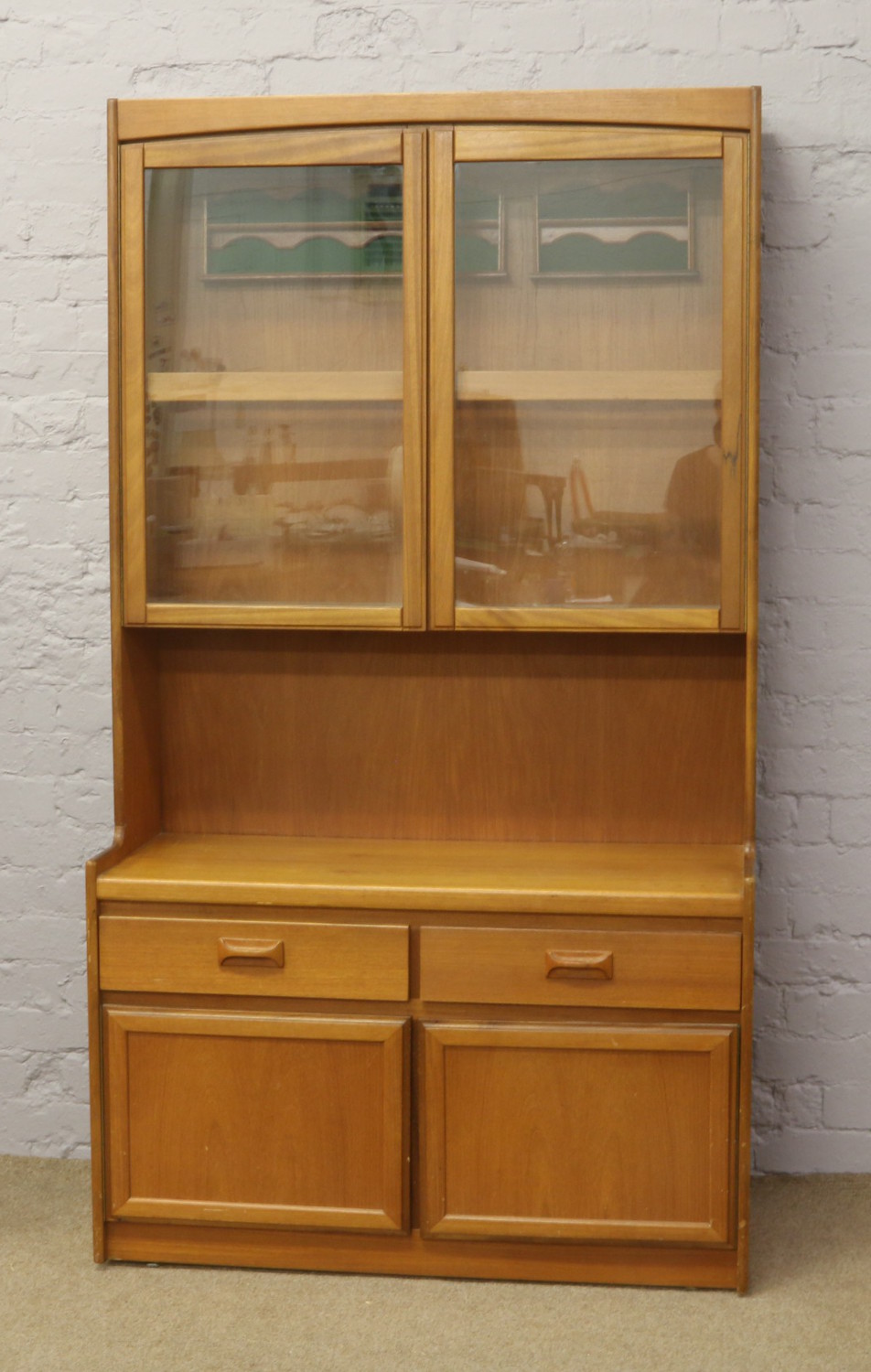 A 1970's teak G plan display unit over cupboard and drawer base.