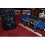 A Powercraft router table along with a large carry case of router accessories.