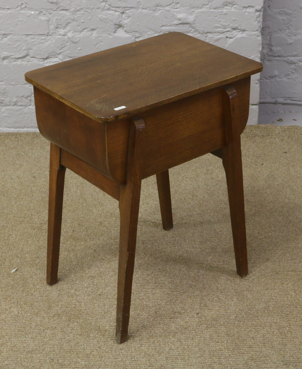 A carved oak work box with lined interior raised on slender tapering legs.