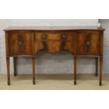 A mahogany serpentine sideboard crossbanded with strung inlay and raised on square tapering