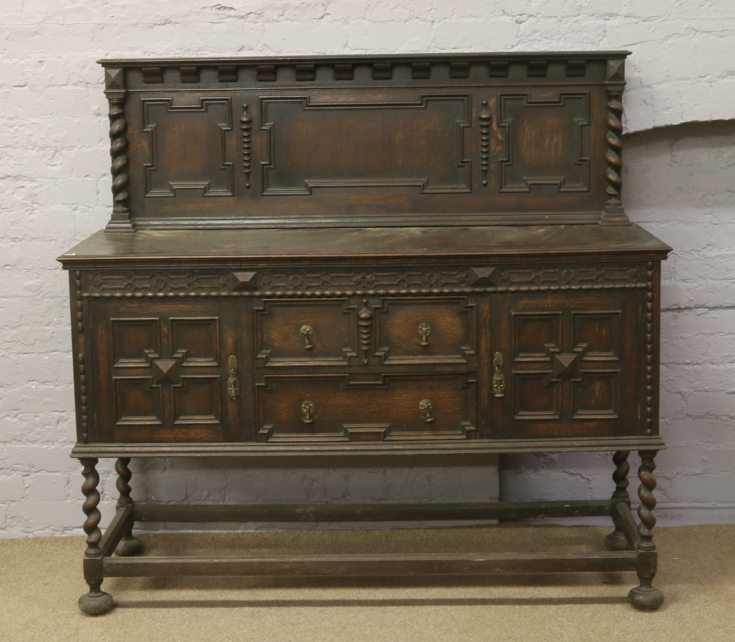 A carved oak sideboard with barleytwist supports.