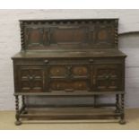 A carved oak sideboard with barleytwist supports.