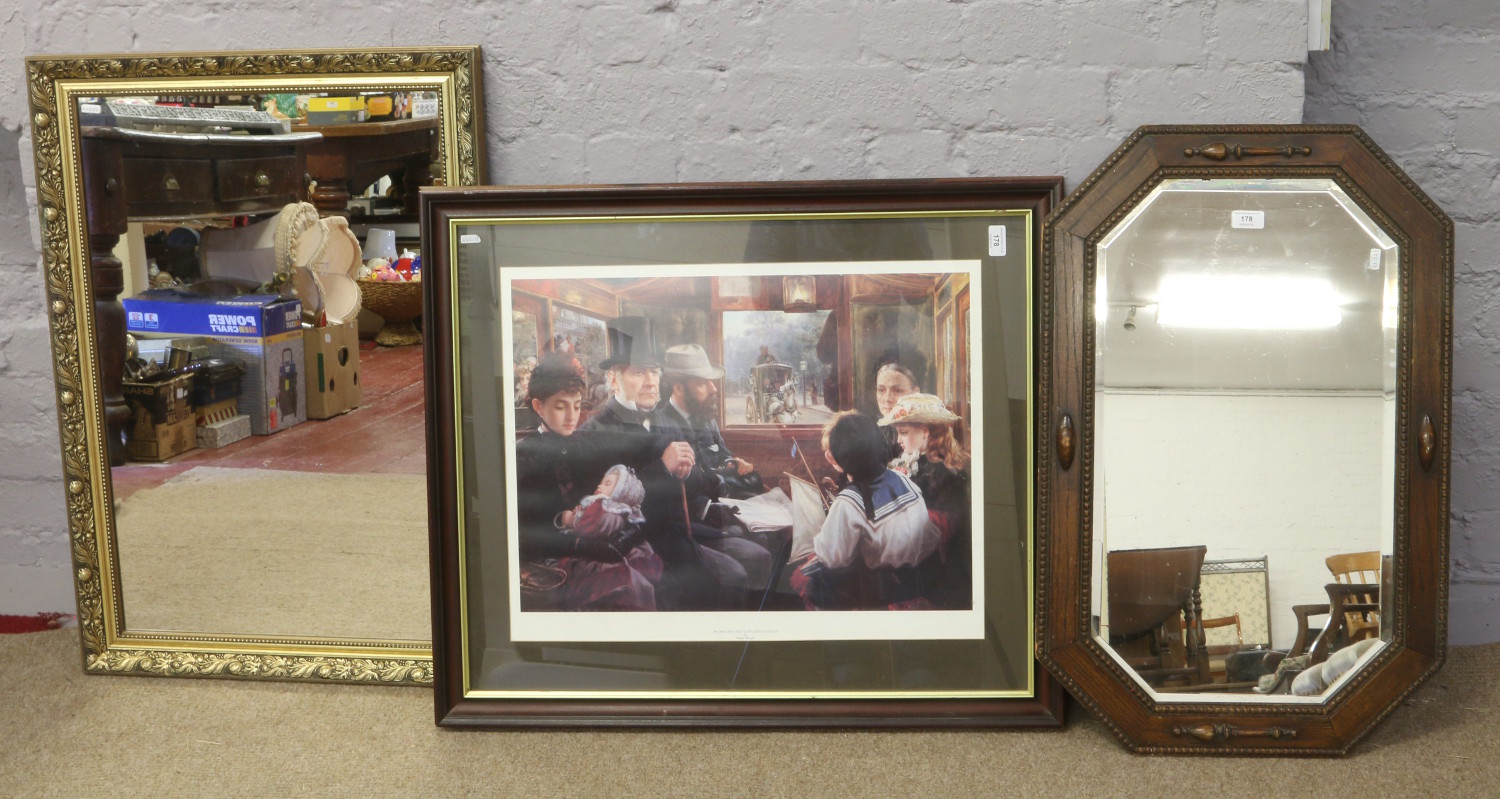 An oak bevel edge wall mirror, along with a gilt framed mirror and a framed print titled an