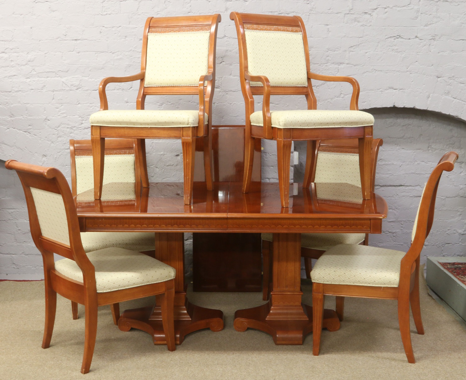 A large extending twin pedestal rosewood dining table, along with four matching upholstered dining