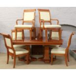 A large extending twin pedestal rosewood dining table, along with four matching upholstered dining