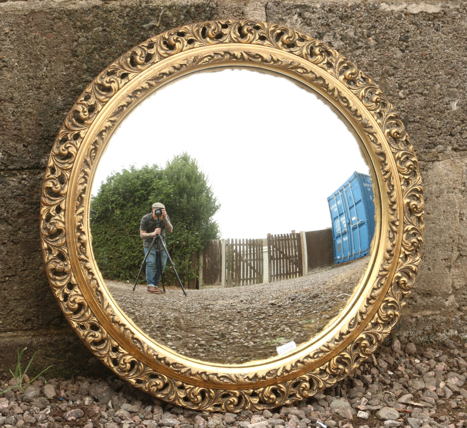 A gilt framed convex wall mirror with pierced scrollwork.