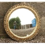 A gilt framed convex wall mirror with pierced scrollwork.