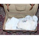 A leather suitcase and contents of lace, linen, dresses etc.