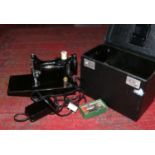 A portable Singer electric sewing machine model number 221K complete with instruction manual and