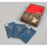 A collection of British and foreign pre-decimal coins in a hardwood case along with three albums