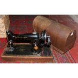 An oak cased Singer sewing machine. Condition report intended as a guide only. Damage to case.