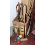 A vintage tea chest and contents of croquet mallets, hoops and balls, along with hockey sticks etc.