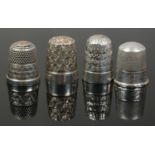 Four silver thimbles.