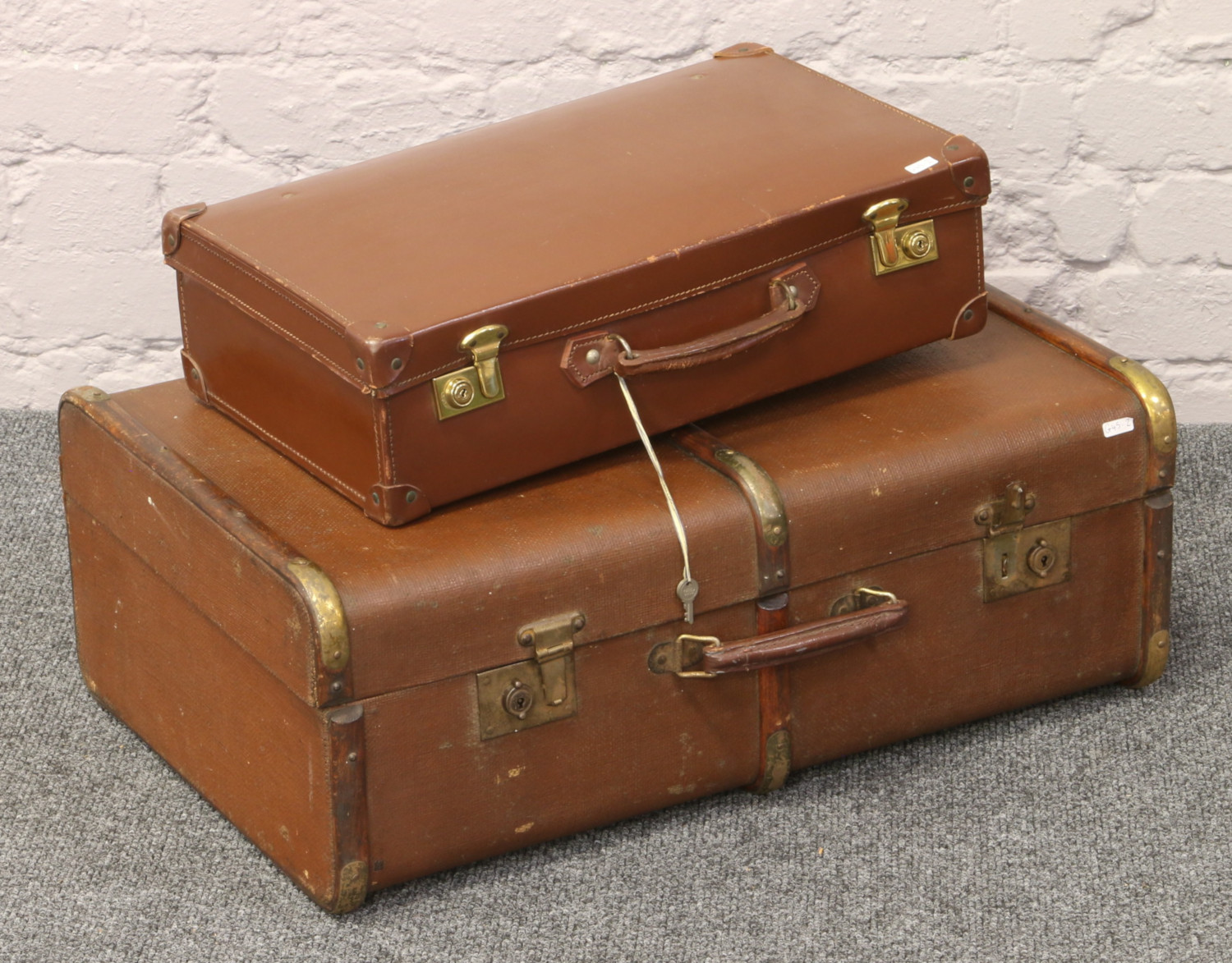 A wood bound travel trunk, along with a vintage suitcase with the original keys.