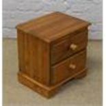 A pine bedside chest of two drawers.