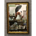 A ornate gilt framed bevel edge wall mirror.