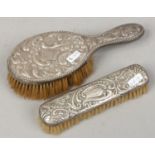 A Victorian silver brush assayed London 1888 along with a similar example, both inscribed Lizzie.