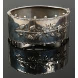 A Victorian silver bangle decorated with applied flowers, assayed Birmingham 1888, 30 grams.