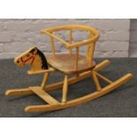 A child's bentwood rocking chair with a carved and painted horse figure head.