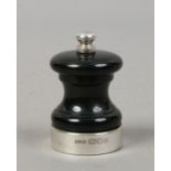 A Peter Piper pepper mill with silver mount, assayed London 1973.