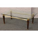 A brass and glass coffee table.